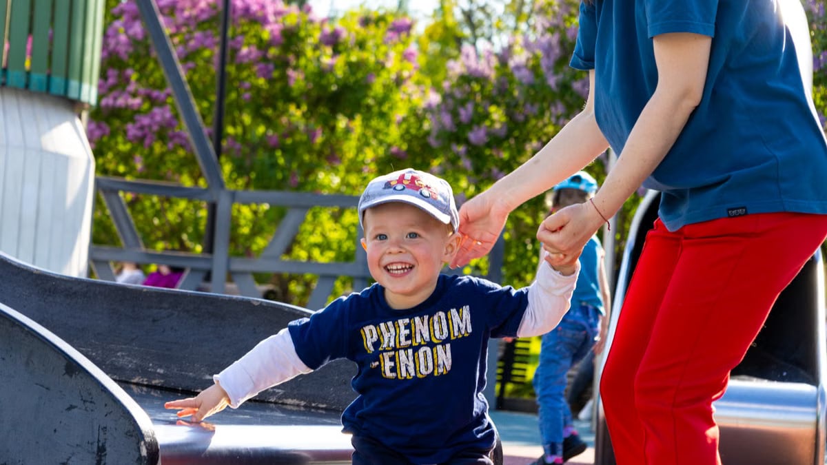 Happy child playing on a slide in a vibrant Russian park, enjoying a sunny day.